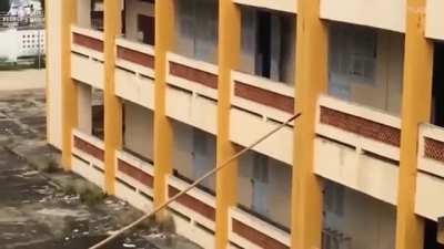 Vietnamese tactical team using bamboo pole to climb up a wall.