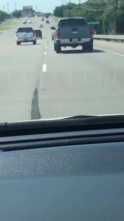 Black car harasses red landscaping truck for several minutes, yelling, brake checking, swerving, chasing, and throwing cans of soda at truck. Recording starts as truck decides he&rsquo;s had enough and runs car off road.
