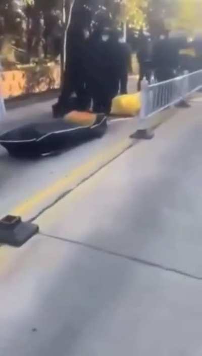 Long line of bodies lying on the street in China waiting to be cremated