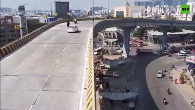 The moment a car loses control and flies off an overpass in India. One soul was lost.
