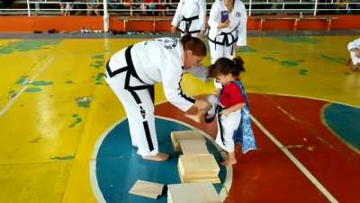 A little girl of 3 years experiences some difficulty in breaking a clipboard in taekwondo