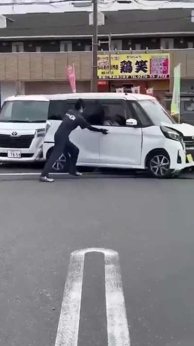 Elderly driver in Japan panics after crashing his car at a tire shop.