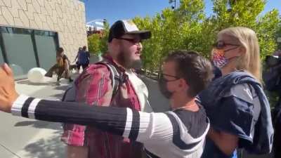 Man with Dave sign clashes with protesters at the Netflix Trans solidarity walkout.