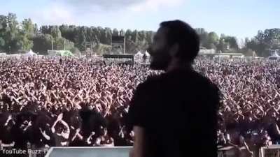 A band&rsquo;s lighting technician signals to his colleague as he tests the stage set-up - and the crowd copies him.