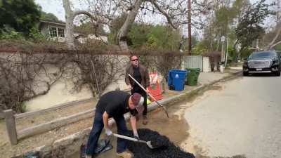 Tired of waiting, Arnold Schwarzenegger fills a giant pothole that&rsquo;s been screwing up cars and bicycles for weeks