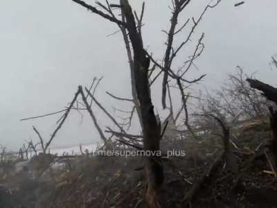 Ukrainian soldier in a trench shoots a Russian soldier approaching their position