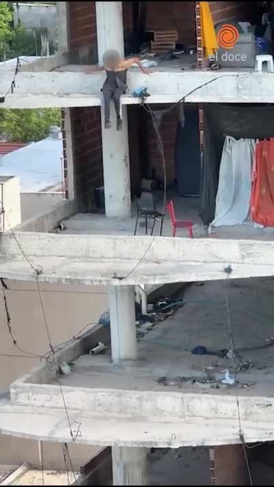 Nene sentado al borde de la cornisa en un edificio tomado en Cordoba - Argentina