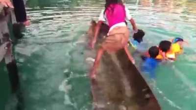 This young girl unswamping a canoe for the people who were in the water.