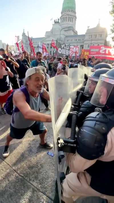 El destape y los medios de comunicación preparan una actuación de un manifestante siendo reprimido por la policía.