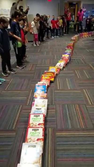 Here is a video of the entire run of cereal box dominos falling at South School today. 600+ boxes of donated cereal dominos makes for a pretty impressive run! Local food pantries will receive the boxes of cereal following this activity.