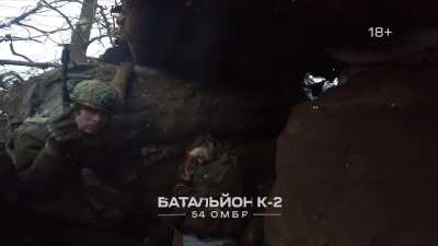 Ukranian Soldiers take cover from gunfire inside a captured Wagner trench, March 2023 Bakhmut. Two Dead Wagner Mercenaries are Visible
