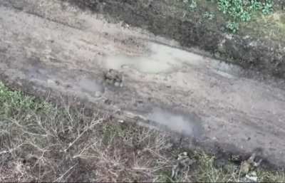 Three orcs lying in the mud next to a street. A drone kills two of them with precise drops