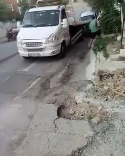 Trying to stop a tow truck slipping with his bare hands
