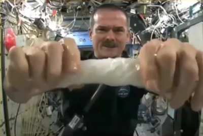 Astronaut Chris Hadfield Wrings a wet towel in Space