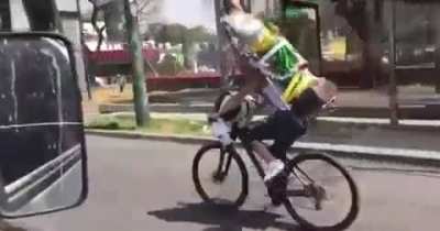 Riding a bike with a big Jesus statue on your back and not looking where you're going