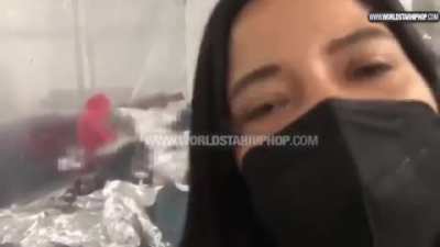 Woman tries her best to stop a guy from exposing their overcrowded migrant detention facility.