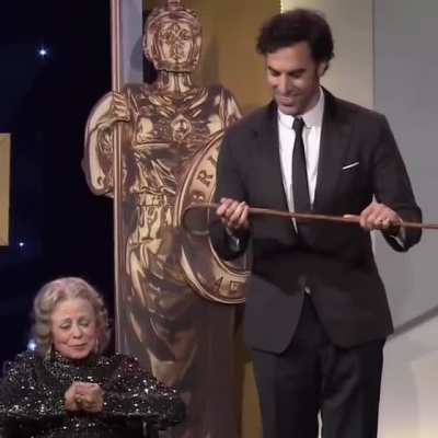 Sacha Baron Cohen going for a test drive with a Charlie Chaplin cane