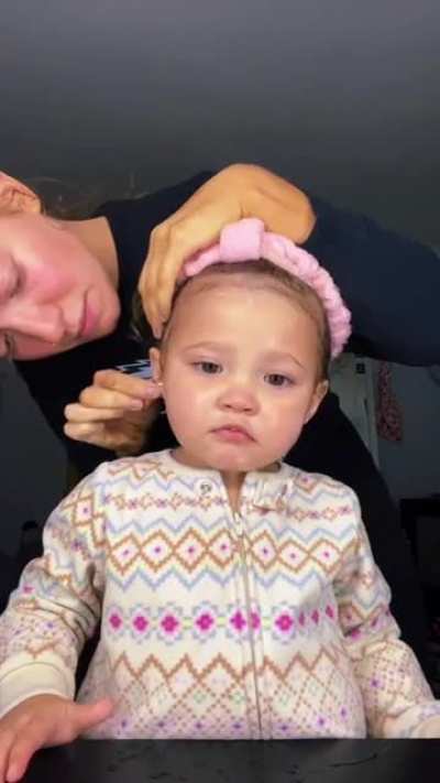 Mom applies brow gel and ice to baby's head to fix her "puffy" morning face