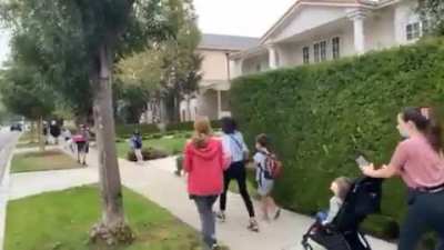 Anti-vaxxers harass parents and children outside of elementary school.