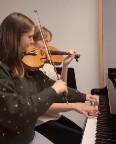Each girl is playing both instruments at the same time