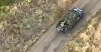 A Russian is dumping comrade's dead bodies from the truck to help it outrun the chasing drone.