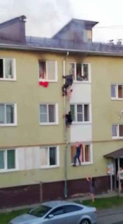 Strangers risk their lives to rescue three children who were trapped inside a burning building.