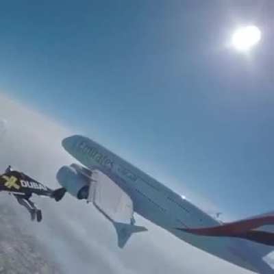 The Swiss Yves Rossi flying with a jetpack at the altitude of 1.2km and at the speed of 315 km/h beside an airplane.