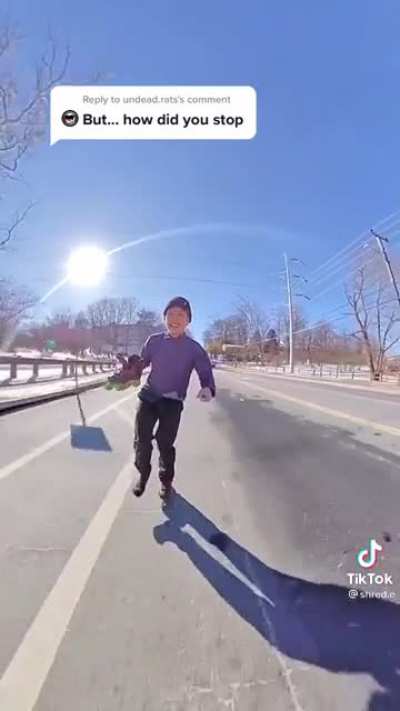 Man rollerblades down a large hill on one foot.