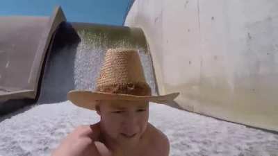 Guy slides down a dam spillway like a water slide