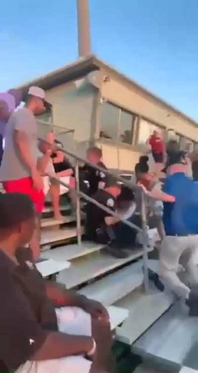A man was asked to leave a track meet for fighting back when asked to stop standing on the rail. Instead he went and sat in the stands. This ensued.