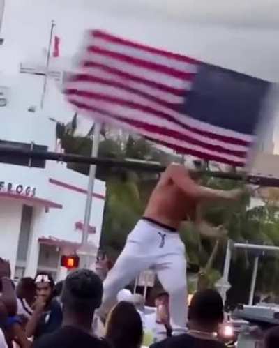 Man paints his face and hair like the Joker, jumps on a car, and screams about how COVID is over during spring break in South Beach
