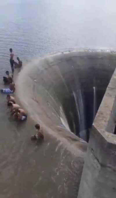 Watch as group of kids stand inches before a dam drain in &Aacute;guas Vermelhas, Minas Gerais, Brazil 😳