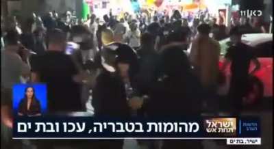 A Group of Israeli settlers brutally assaulting Palestinian young man in " Beit Yam live on TV
