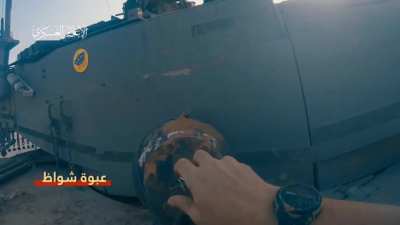 Al Qassam brigades puts an explosive device on an Israeli tank and detonates it.