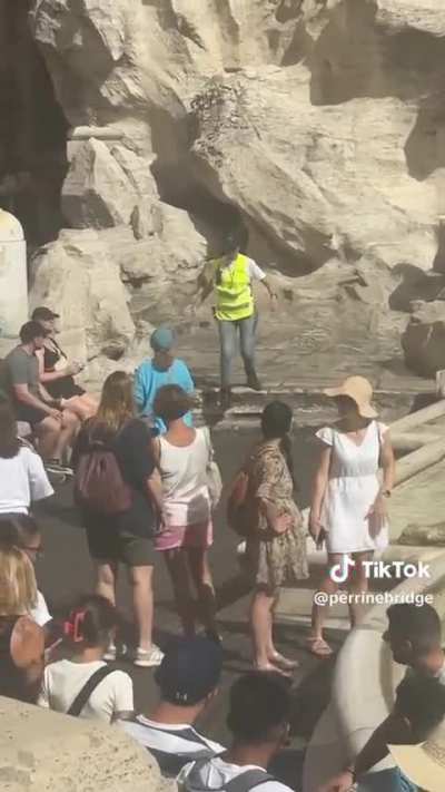 tourist fills her water bottle at Rome&rsquo;s Trevi Fountain