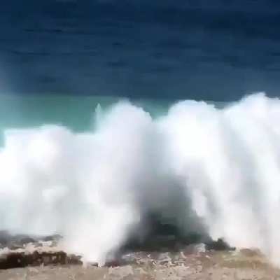 Wakeboarding straight into a breaking wave coming upon the land