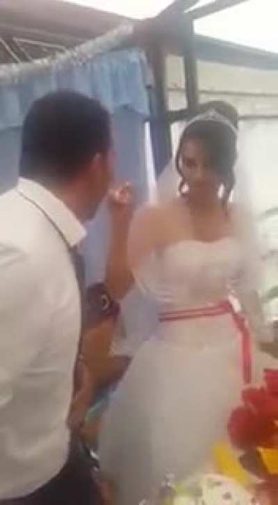 man slaps wifes hand, during their wedding, when she was playful with him
