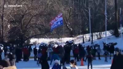 Is this even safe? Trump supporter waving huge flag while ice skating on a busy rink - ice skaters were not impressed and dealt with him