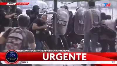 En las manifestaciones comtra el fmi, los manifestantes le tiraron una bomba molotov hacia la policia