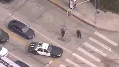 Cops fall off truck, then one wildly pepper sprays the air for no reason.