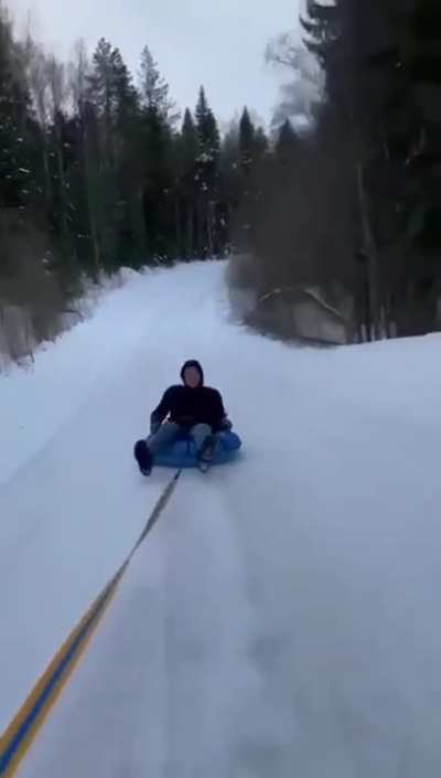 Idiot On Sled Getting Pulled By Car