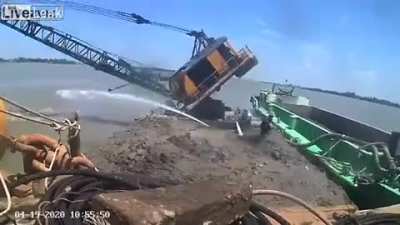 Excavator falls into the river