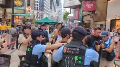 A young man holding a copy of "May 35", the book version of Candace Chong's Tiananmen play, was taken for a search, and minutes later taken away on a police van. He gave a thumbs up gesture as he was led away by officers.