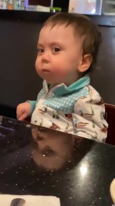 Kid is determined, but struggling, to endure first taste of spicy pepper.