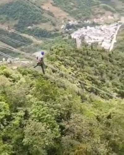 Lineman sliding down power lines
