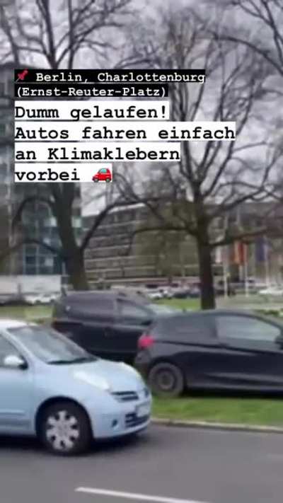 Cars drive around climate protesters in Berlin