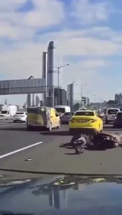 Main character motorcycle driver slaps other driver&rsquo;s mirror and then crashes his motorcycle behind another vehicle.