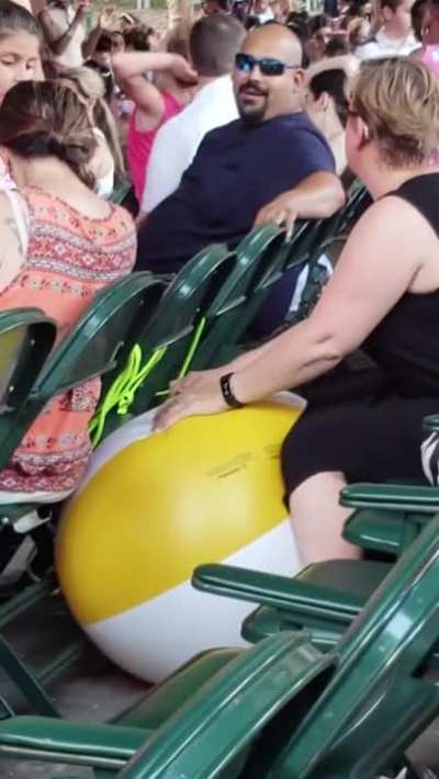 Lady deflating beachballs at a children&rsquo;s concert