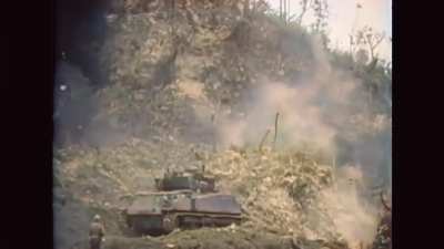 June 1945, Sherman tank equipped with a Flamethrower attacks a Japanese strongpoint on Okinawa