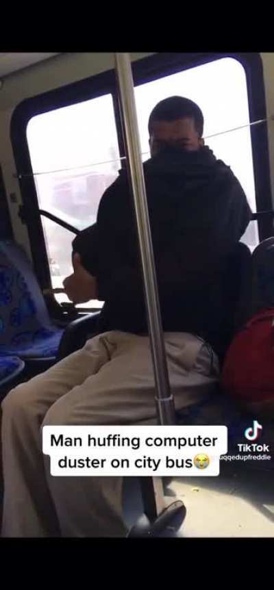 Man huffing computer duster on a city bus.